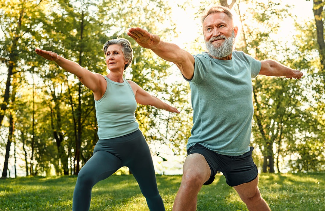 Exercise A senior man and woman doing yoga in the park