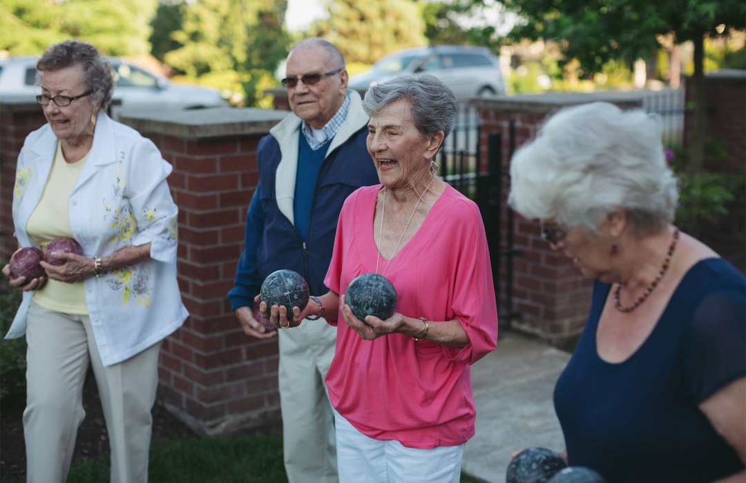 Assisted Living vs. Nursing Home Group of people holding bocce balls