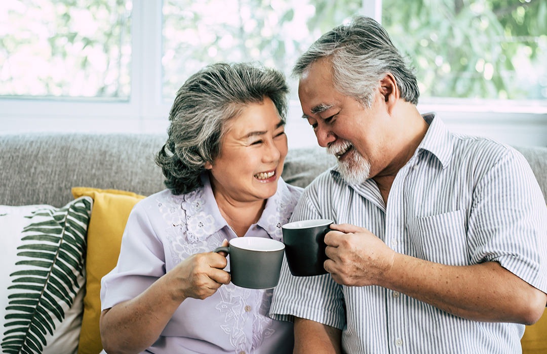 Lifestyle couple sitting on their couch drinking coffee