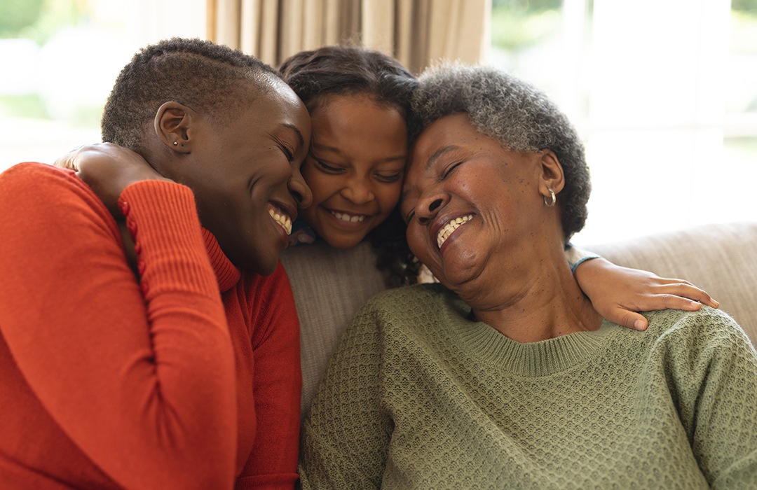 Lifestyle Family sitting on their couch hugging and smiling