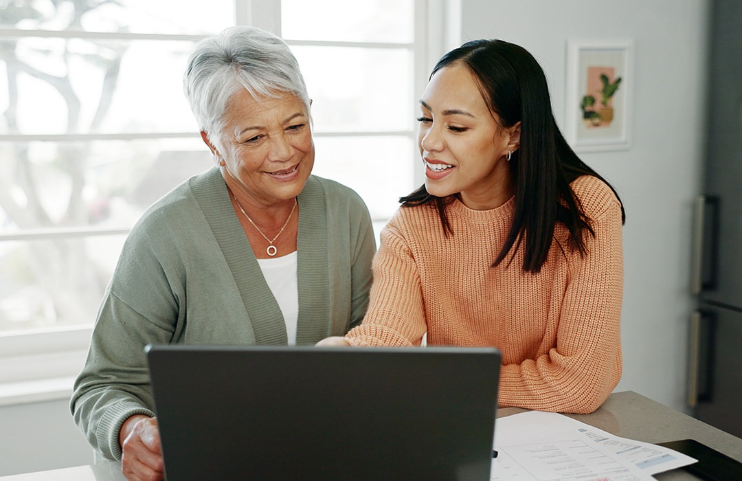 Lifestyle Two women smiling looking at a computer