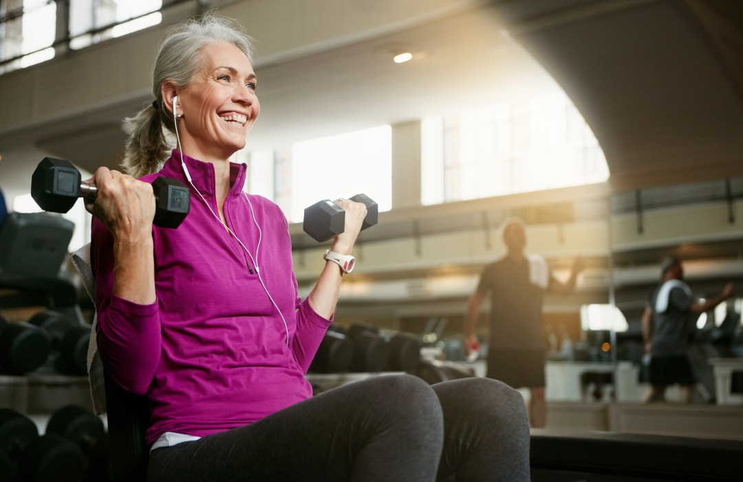Importance of Strength Training Older woman lifting dumbbells in gym