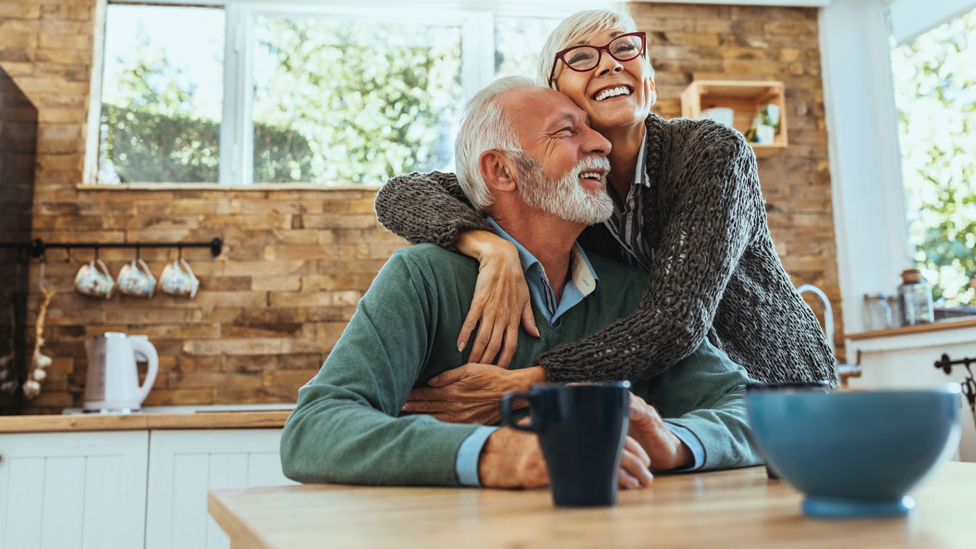 Lifestyle Couple hugging in a well lit kitchen