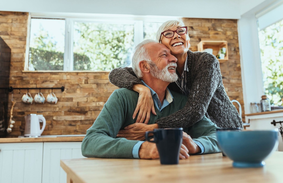 Lifestyle Couple hugging in a well lit kitchen